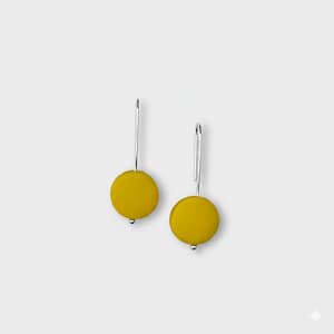 An elegant set of silver earrings with a yellow polymer clay bead